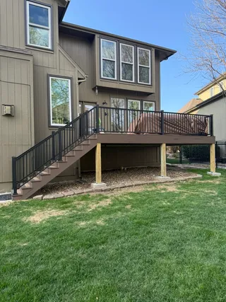 New custom composite deck with black metal railing after construction